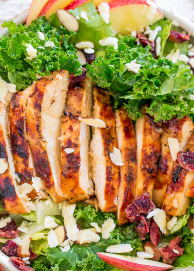 Grilled chicken salad with kale, apples, cranberries, and almonds.