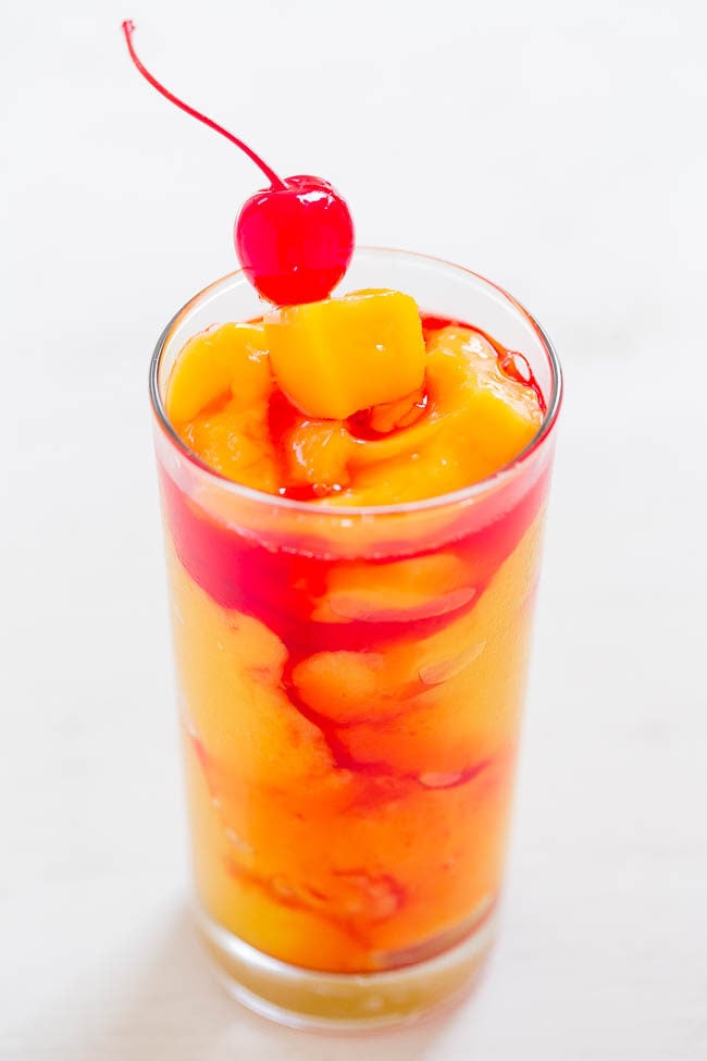 Kiss On The Lips Cocktail - Frozen mango, rum, vodka, peach schnapps, and a KISS of drizzled grenadine!! Fruity, tropical, and they go down way too easily!!