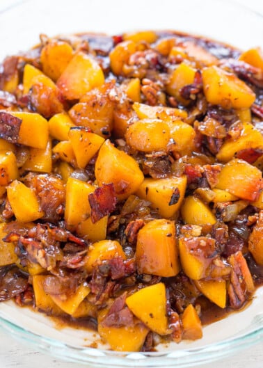 A dish of candied sweet potatoes with pecans.