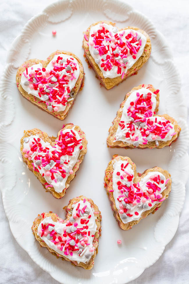 Soft Frosted Valentine Heart Cookies - The EASIEST cutout cookies you'll ever make!! No rolling pin, no mixer, no chilling the dough! Soft and chewy with plenty of frosting and sprinkles!!