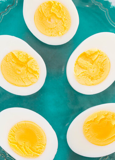 Four halved hard-boiled eggs arranged on a turquoise plate.