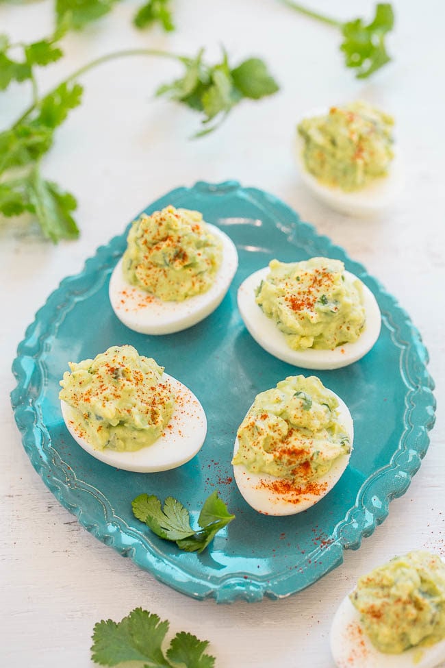 Avocado Deviled Eggs - GUACAMOLE inspired filling jazzes up regular deviled eggs and makes them addictively good!! EASY, tasty, and a perfect little snack or party appetizer!!