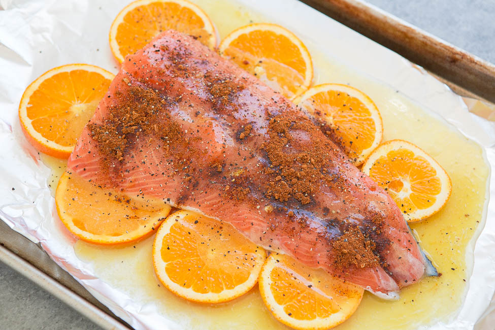 Seasoned salmon fillet on a bed of orange slices.