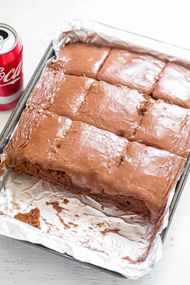A Coca-Cola Cake in a pan, cut into slices with a row missing. 