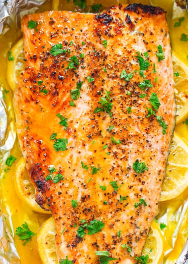 Baked salmon fillet with lemon and herbs on foil.