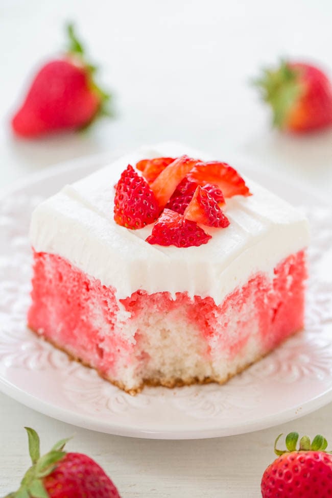 A slice of Strawberries and Cream Poke Cake  on a white plate 