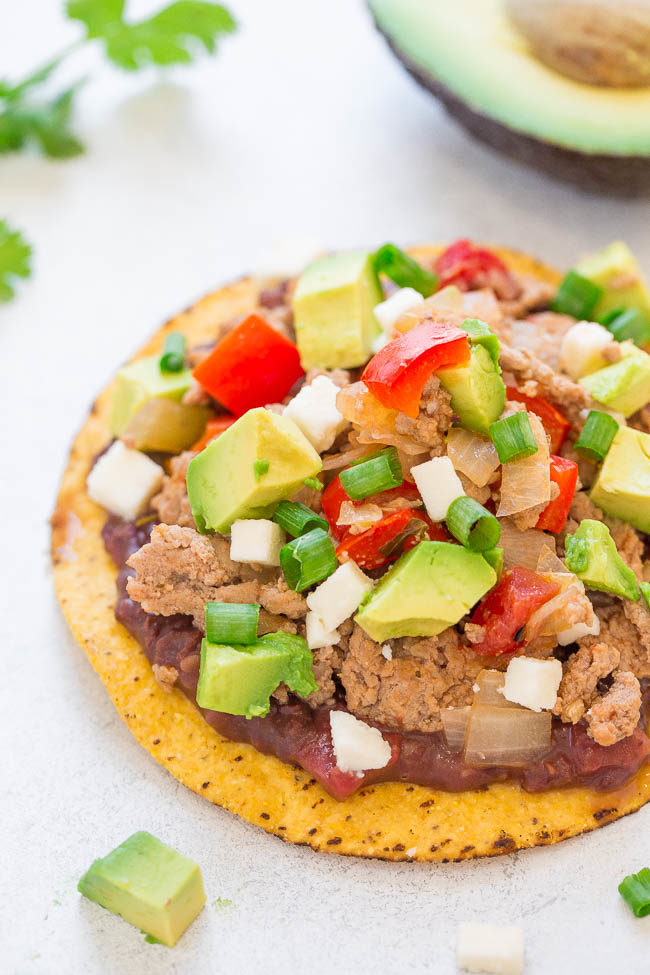 Easy Loaded Chicken Tostadas - Ready in 20 minutes and LOADED to the max!! Chicken, refried beans, peppers, salsa, cheese, and more!! Great party appetizer or EASY weeknight dinner!!