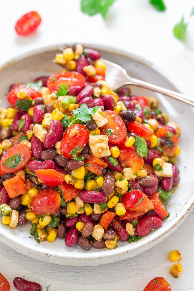 Skinny Mexican Bean and Corn Salad in a white bowl with a fork
