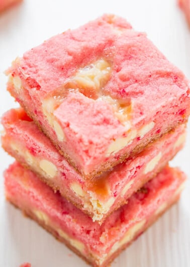 A stack of pink strawberry bars with a visible layer of fruit filling.