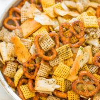 A bowl of mixed savory snacks, including pretzels and seasoned crackers.
