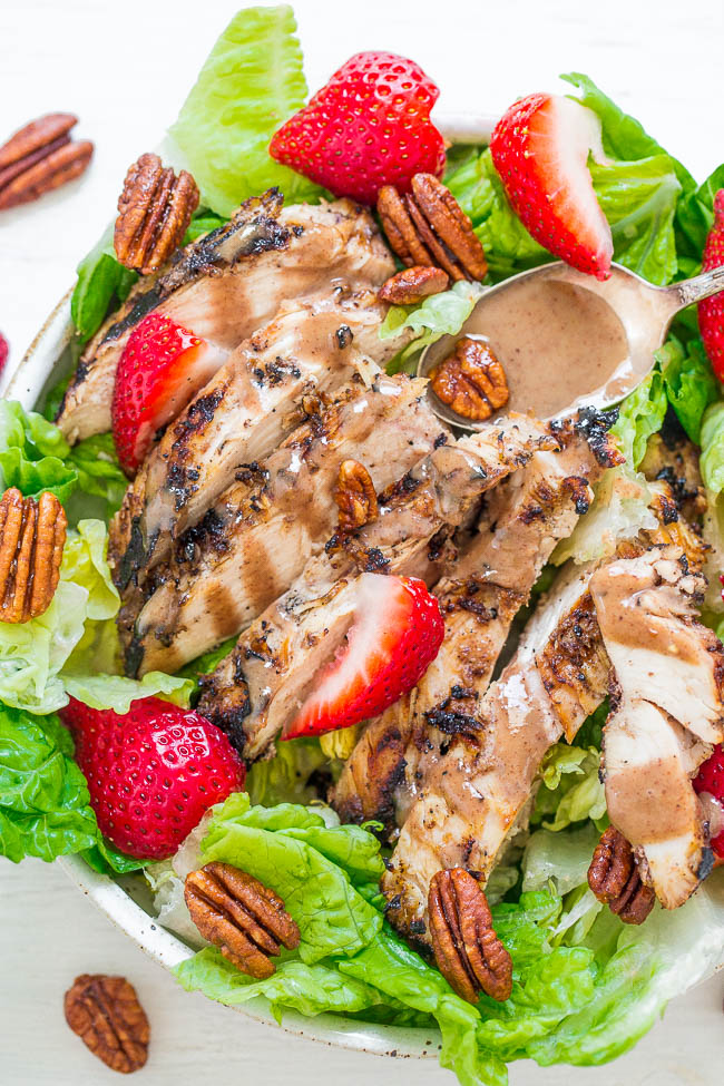 close up of strawberry salad topped with grilled chicken