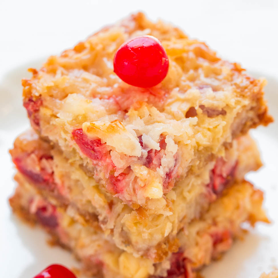 Stack of coconut cherry bars with a maraschino cherry on top.