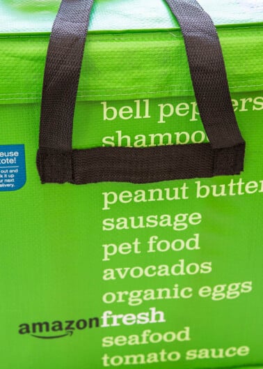 Green amazon fresh insulated grocery delivery tote with a list of grocery items printed on the side.