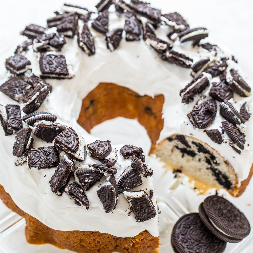 A bundt cake topped with white icing and crushed oreo cookies.
