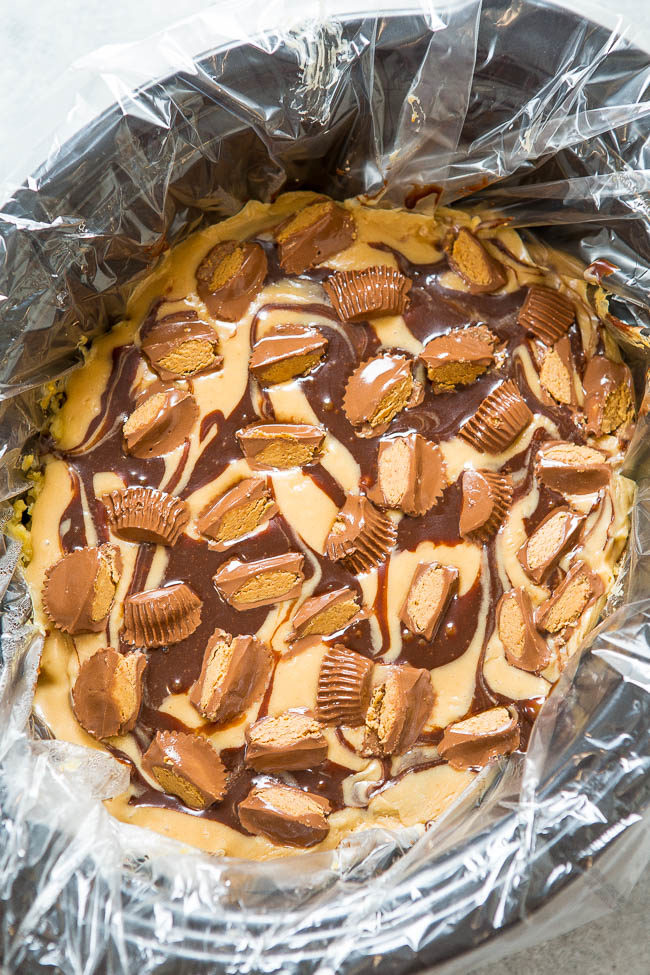 Slow Cooker Peanut Butter Cup Swirl Cake - Yellow cake is spiked with peanut butter, hot fudge, topped with a peanut butter glaze, more hot fudge, and sprinkled with peanut butter cups!! It's rich, decadent, SO EASY, and made in a slow cooker!!