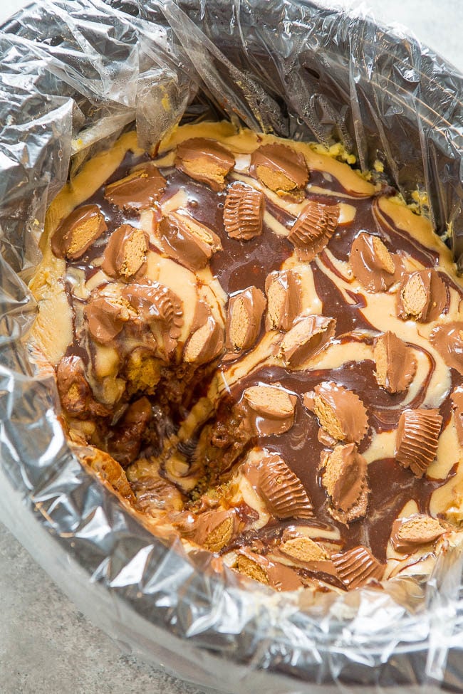 Slow Cooker Peanut Butter Cup Swirl Cake - Yellow cake is spiked with peanut butter, hot fudge, topped with a peanut butter glaze, more hot fudge, and sprinkled with peanut butter cups!! It's rich, decadent, SO EASY, and made in a slow cooker!!