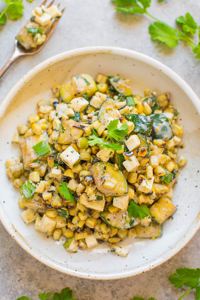 Creamy Mexican Grilled Corn and Zucchini Salad - A healthy EASY salad that's ready in 15 minutes and so flavorful!! Corn, zucchini, cilantro, queso fresco and more are tossed in a DELISH creamy lime sauce!!