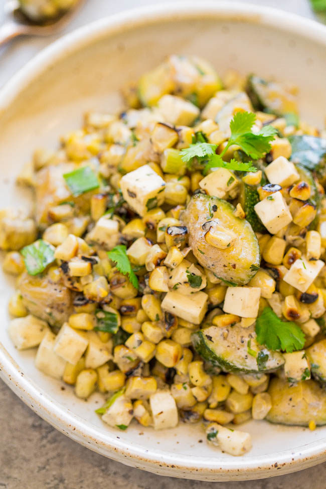 A white bowl filled with Creamy Mexican Corn Salad with Zucchini