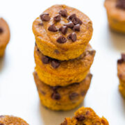 Stack of pumpkin chocolate chip muffins on a white surface.