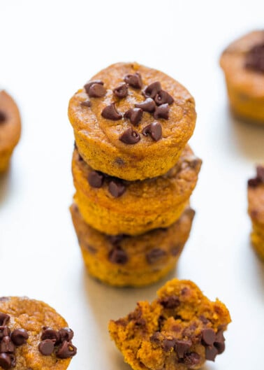 Stack of pumpkin chocolate chip muffins on a white surface.