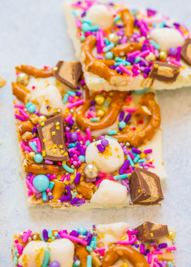 Colorful candy-covered dessert bars with sprinkles, pretzels, and chocolate pieces.