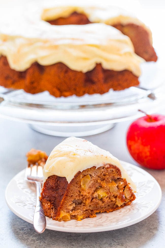 A slice of Apple Spice Cake with Cream Cheese Frosting on a white plate with fork