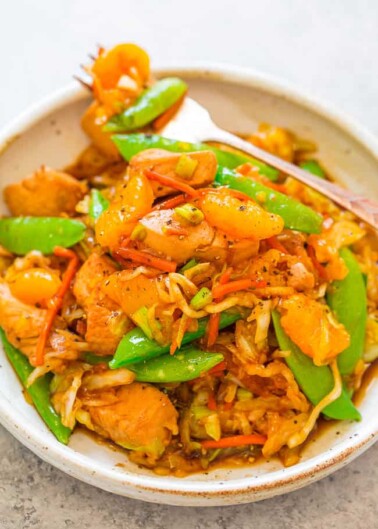 A bowl of stir-fried shrimp with vegetables.
