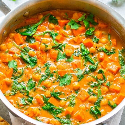 A pot of chickpea and spinach curry served with flatbread.