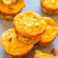 Freshly baked breakfast egg muffins with cheese and ham on a baking sheet.