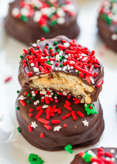 Holiday-themed chocolate-dipped cookies decorated with red and green sprinkles.