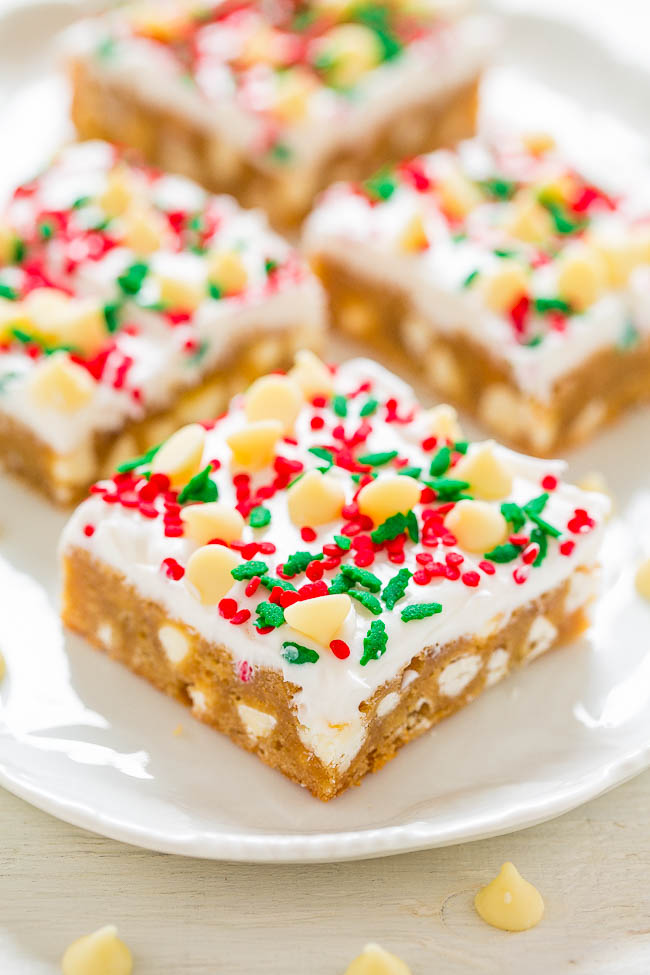 four frosted white chocolate blondies on a white platter 