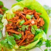 A lettuce wrap filled with seasoned ground meat and vegetables, garnished with fresh cilantro.