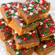 A stack of homemade holiday caramel squares topped with chocolate and festive red and green sprinkles.