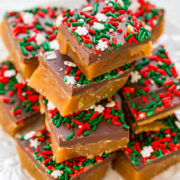A stack of homemade holiday caramel squares topped with chocolate and festive red and green sprinkles.