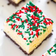 A festive cheesecake bar with sprinkles on top, displayed on a white surface.