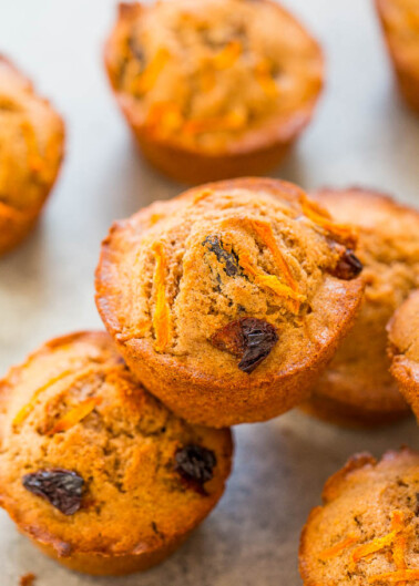 Freshly baked carrot muffins with raisins on a baking tray.