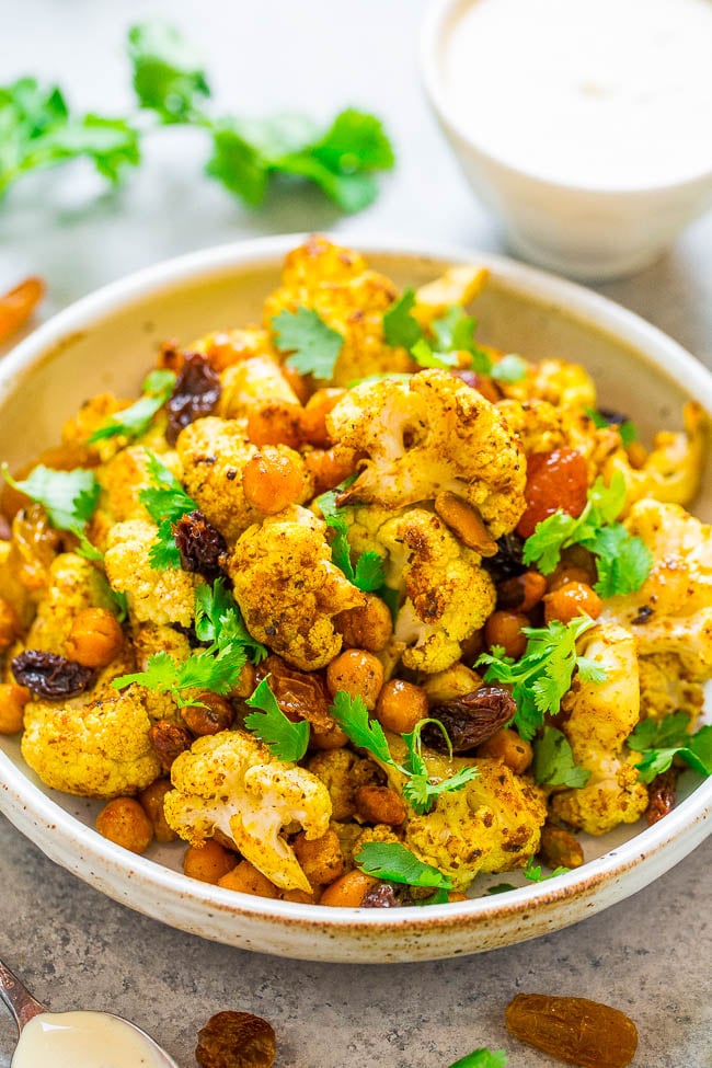 Roasted Curried Cauliflower and Chickpea Salad - An EASY, healthy, lettuce-less salad with roasted curried cauliflower and chickpeas as the STARS!! Topped with raisins, pistachios, cilantro, and a DELISH tangy Greek yogurt dressing!!