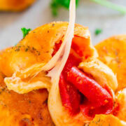 Stuffed cheese bread with melted cheese and red pepper filling being pulled apart.