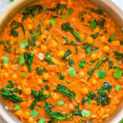 A pot of chickpea and spinach curry garnished with cilantro.