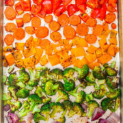 Assorted chopped vegetables seasoned and ready for roasting on a baking sheet.
