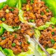 Stuffed lettuce cups with savory ground meat and diced vegetables, garnished with chopped green onions.
