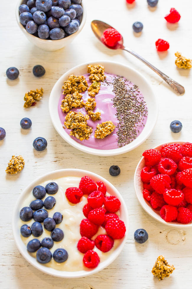 Fruit and Granola Yogurt Bowls topped with raspberries and blueberries