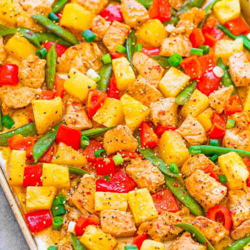 Oven-roasted chicken and mixed vegetables on a baking sheet.