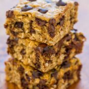 A stack of chocolate chip oatmeal bars on a wooden surface.