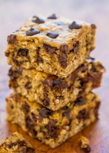 A stack of chocolate chip oatmeal bars on a wooden surface.