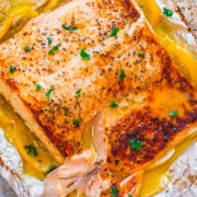Grilled salmon fillet with herbs and lemon butter sauce in foil.