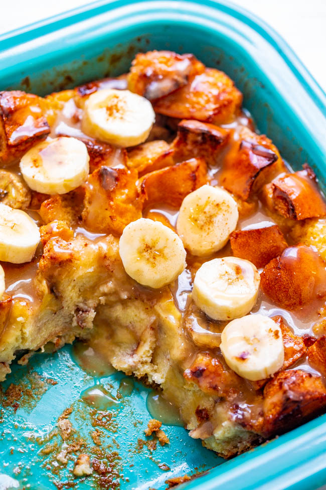 homemade bread pudding with bananas in a blue casserole dish. A slice is missing. 