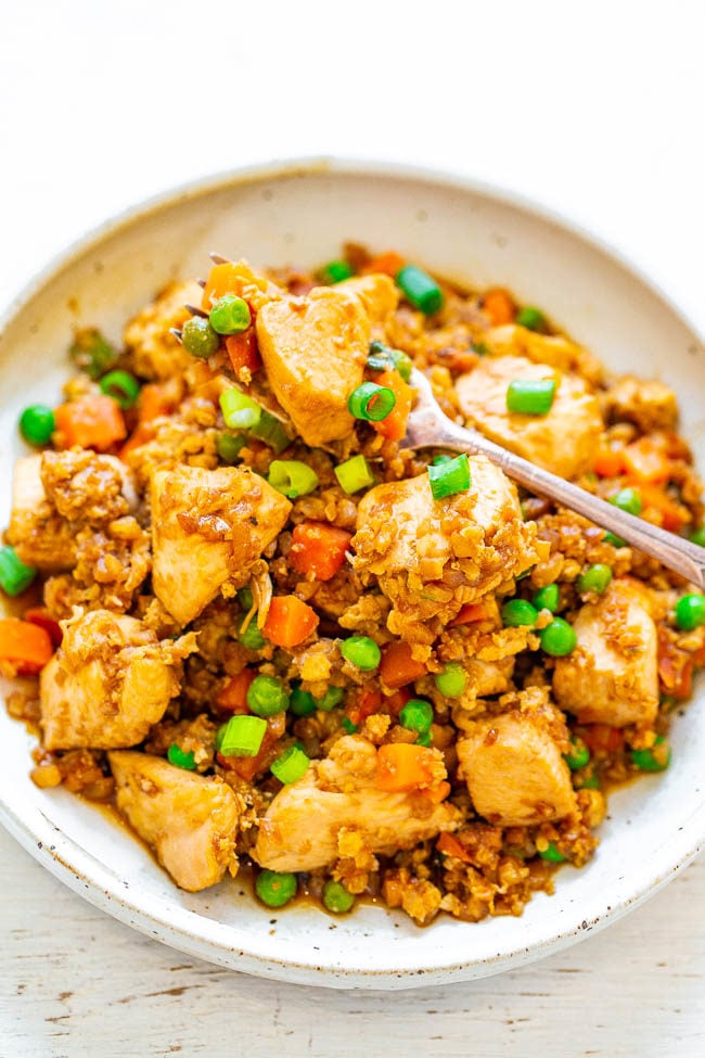 Skinny Chicken Cauliflower Fried Rice in a white bowl with a fork