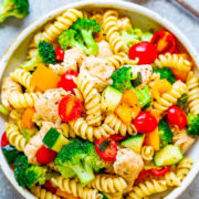 A vibrant bowl of chicken pasta salad with broccoli, cherry tomatoes, and bell peppers.