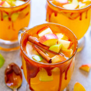 Three glasses of fruit punch garnished with cinnamon sticks and diced fruits, with a caramel drizzle on the rim.